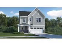 Charming two-story home with gray siding, stone accents, covered entry, and a two-car garage at 347 Canyon Spring Trl, Wake Forest, NC 27587