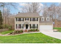 Charming two-story home with a well-maintained lawn and a basketball hoop in the driveway at 415 King George Loop, Cary, NC 27511