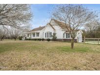 Charming white home with a beautiful yard, flowering trees, and a gated driveway at 582 Ebenezer Church Rd, Coats, NC 27521