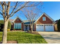 Charming brick home with a well-manicured lawn and a two-car garage at 9813 Derbton Ct, Raleigh, NC 27617