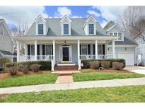 Charming home featuring a welcoming front porch, complemented by manicured landscaping and a brick walkway at 103 Glade St, Chapel Hill, NC 27516
