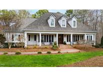 Charming home featuring a brick walkway leading to a column-lined front porch with rocking chairs at 106 Woodkirk Ln, Chapel Hill, NC 27514