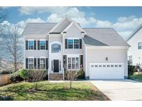 Charming two-story home featuring a manicured lawn, two car garage and beautiful architectural details at 1305 Fenwick Pkwy, Durham, NC 27713