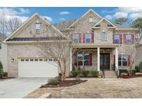 Charming two-story brick home with red shutters, attached two-car garage, and well-manicured front yard at 1408 Magnolia Bend Loop, Cary, NC 27519