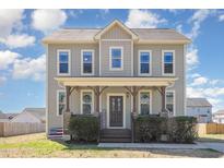 Charming two-story home with inviting front porch and beautifully maintained landscaping at 145 Carissa Dr, Smithfield, NC 27577