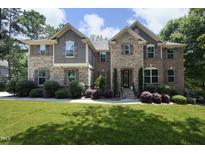 Beautiful two-story home featuring a well-manicured lawn and a stone and brick facade at 156 Stoney Creek Way, Chapel Hill, NC 27517