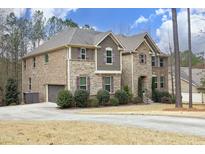 Beautiful two-story home boasting a stone and brick facade, complemented by a well-manicured lawn and a spacious driveway at 156 Stoney Creek Way, Chapel Hill, NC 27517