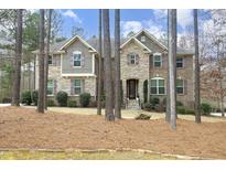Inviting two-story home with stone and siding, surrounded by mature trees and landscaped yard at 156 Stoney Creek Way, Chapel Hill, NC 27517