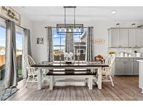Light and airy dining room with modern lighting, rustic table, and sliding door to the outside at 190 Hickory Run Ln, Franklinton, NC 27525