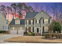 Charming two-story home with a two-car garage, black shutters, and manicured landscaping at sunset at 200 Parkbranch Ln, Cary, NC 27519