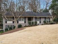 Charming single-Gathering home featuring a landscaped front yard and classic design with gray brick at 2001 Manuel St, Raleigh, NC 27612