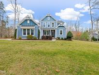 Beautiful, two-story blue home featuring a well-maintained lawn and inviting curb appeal at 2253 Greenbrook Ln, Durham, NC 27705