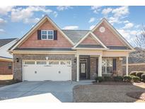 Charming brick home featuring a manicured lawn, two-car garage, and inviting covered front porch at 231 Easy Wind Ln, Garner, NC 27529