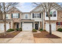 Charming townhomes showcasing a mix of stone and siding, each with a one car garage and well-manicured landscaping at 2451 Memory Ridge Dr, Raleigh, NC 27606