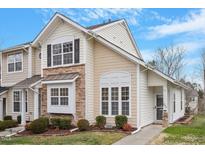 Charming townhome featuring stone accents, multiple windows, and manicured landscaping at 302 Red Elm Dr, Durham, NC 27713