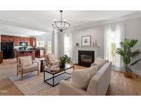 Bright living room with fireplace, hardwood floors, and open access to the kitchen at 3439 Archdale Dr, Raleigh, NC 27614