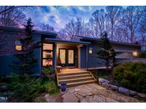 Charming home featuring stone walkway, wooden steps, and a beautifully illuminated entryway at 3604 Pasture Rd, Hillsborough, NC 27278