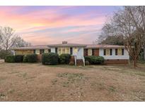 Charming single-story home featuring brick accents, white siding, and a well-manicured front yard at 410 E Mcneill St, Lillington, NC 27546