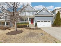 Charming two-story home with a red front door, attached two-car garage, and a well-maintained front yard at 4128 Enfield Ridge Dr, Cary, NC 27519