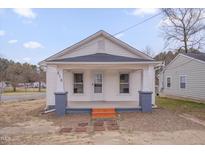 Charming home featuring a covered front porch, white siding, and a well-maintained yard at 516 Craven Road, Durham, NC 27704