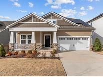 Beautiful home featuring stone accents, solar panels, and a two-car garage at 721 Sage Oak Ln, Holly Springs, NC 27540