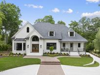 Beautiful two-story brick home with mature landscaping, a curved driveway and inviting front porch at 7217 Manor Oaks Dr, Raleigh, NC 27615
