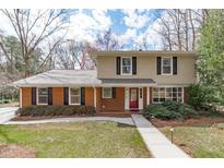 Charming two-story home featuring a brick facade, complemented by dark shutters and a well-maintained front yard at 8801 Lakewood Dr, Raleigh, NC 27613