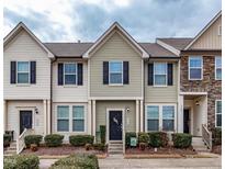Charming townhouse featuring a neatly landscaped front yard and complementary exterior color scheme at 9845 Sweet Basil Dr, Wake Forest, NC 27587