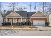 Charming brick home with a covered front porch and well-manicured landscaping at 1056 Lukestone Dr, Fuquay Varina, NC 27526
