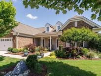 Charming brick home with well-manicured lawn and colorful landscaping at 127 Gadwall Ln, Durham, NC 27703