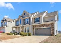 Charming two-story home with stone accents, covered porch, and attached two-car garage at 130 Campaign Dr, Mebane, NC 27302