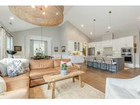Open-concept living room with modern lighting, hardwood floors, and a seamless flow into the kitchen at 1327 Gloriosa St, Apex, NC 27523