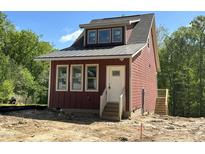 Charming new construction home featuring red siding and a metal roof nestled in a wooded lot at 1448C Maplewood Dr, Durham, NC 27704