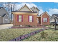 Charming brick home featuring red shutters, manicured landscaping, and inviting front entrance at 1709 Shamrock Ln, Rocky Mount, NC 27804