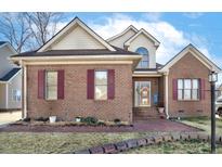 Charming brick home featuring burgundy shutters and a manicured front yard landscape at 1709 Shamrock Ln, Rocky Mount, NC 27804
