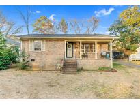 Charming brick home with a covered front porch and well-maintained yard at 203 Prince St, Carrboro, NC 27510