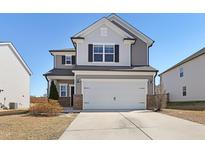 Charming two-story home with a two-car garage and neutral siding against a bright blue sky at 2105 Attend Xing, Fuquay Varina, NC 27526