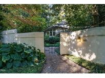 Inviting gated entrance of a home with lush landscaping and a stone pathway, creating a private and serene ambiance at 3601 Swann St, Raleigh, NC 27612