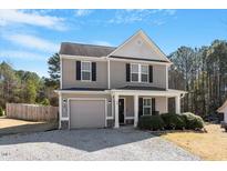 Charming two-story home with grey siding, black shutters, and a cozy front porch at 40 Golden Timber Cir, Four Oaks, NC 27524