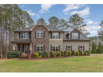 Charming two-story home featuring a blend of stone and siding, accented by well-manicured landscaping and a lush green lawn at 6712 Stepherly Way, Holly Springs, NC 27540