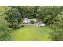 Charming home features well-maintained lawn with detached garage, surrounded by lush trees at 7101 Winding Way, Wake Forest, NC 27587