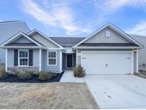 Charming single-story home with gray siding, attached garage, and manicured landscaping at 737 Little Patch St, Zebulon, NC 27597