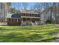 Charming brick home features a wide front porch, perfect for enjoying the outdoors at 1013 Traders Trl, Wake Forest, NC 27587