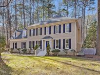 Traditional two-story home featuring a manicured lawn and mature trees at 10317 Roadstead W Way, Raleigh, NC 27613