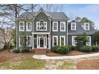 Charming two-story home with detailed trim, mature landscaping, and inviting front porch at 113 Preston Pines Dr, Cary, NC 27513