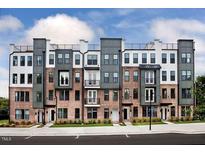 A modern townhome complex showcasing brick facades, stylish accents, and rooftop terraces under a partly cloudy sky at 1257 S Blount Street # 201, Raleigh, NC 27601