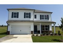 Two-story home with white siding, black shutters, a two-car garage, and manicured lawn at 131 E Victory View. Ter, Smithfield, NC 27577