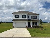 Two-story home featuring a two-car garage, neutral siding, and a well-manicured lawn at 131 E Victory View. Ter, Smithfield, NC 27577