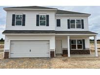 New two-story home with white siding, stone accents, dark shutters, and a two-car garage in a modern community at 131 E Victory View. Ter, Smithfield, NC 27577