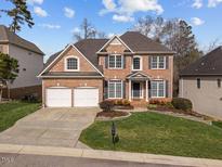 Beautiful two-story brick home with a well-manicured lawn, two-car garage and mature landscaping at 13121 Sargas St, Raleigh, NC 27614